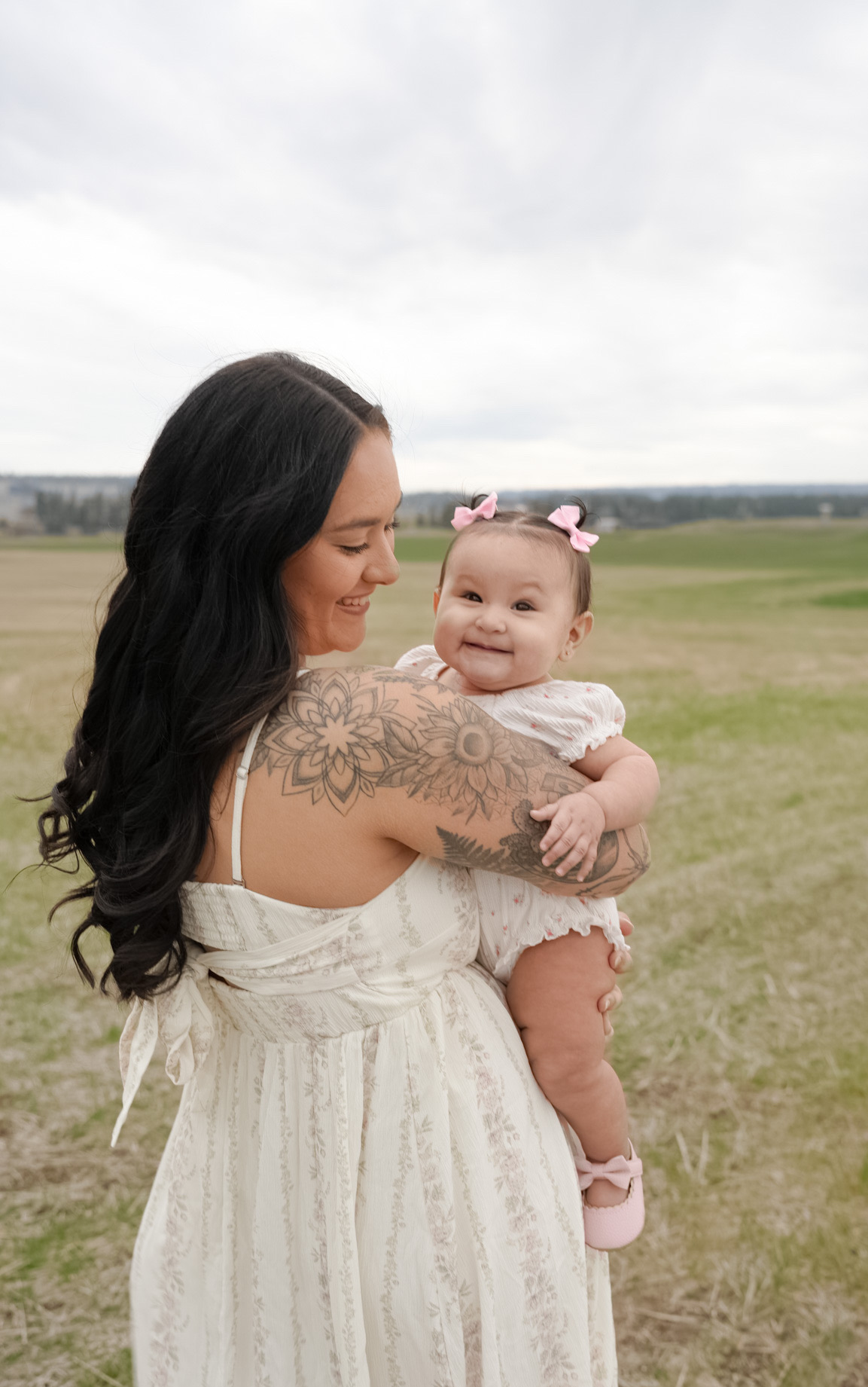 A mother lifting her baby daughter into the air